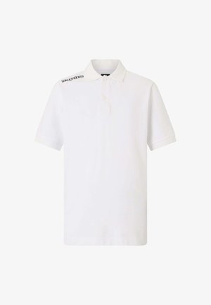 Chemise polo blanche en coton, dotée d'un col, de deux boutons et d'un logo noir sur l'épaule gauche. Manches courtes avec un ourlet droit.