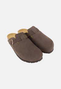 Braune Wildleder-Clogs mit runder Spitze, ausgestattet mit einem Riemen und eine verstellbare Schnalle. Das Innere hat eine beigen gepolsterten Sohle und eine strukturierte Gummisohle.