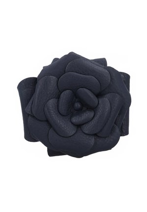 Dunkel marineblaues Leder-Accessoire in Blumenform mit geschichteten, abgerundeten Blütenblättern, die spiralartig angeordnet sind.
