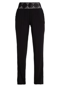 Pantalones negros con una cinturilla ancha y texturizada que presenta un patrón recortado. La tela es suave y se desliza libremente hasta los tobillos.