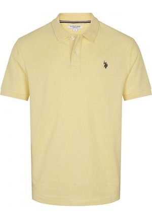 Żółta koszulka polo z teksturowanej tkaniny, z kołnierzykiem, zapięciem na dwa guziki, krótkimi rękawami i małym czarnym logo na klatce piersiowej.