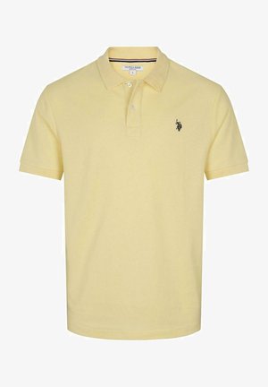 Polo jaune en tissu texturé, avec un col, un patte de boutonnage à deux boutons, des manches courtes et un petit logo noir sur la poitrine.