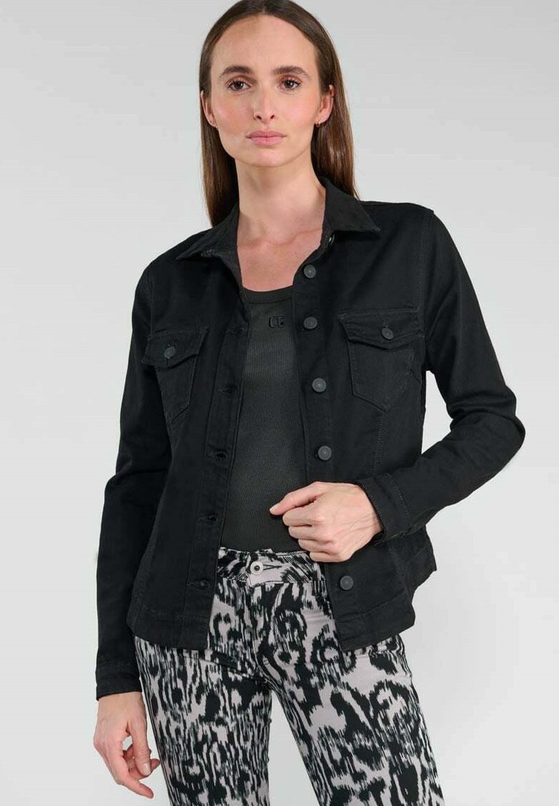 Zwart denimjack met knoopsluiting aan de voorkant, twee borstzakken en een gestructureerde kraag, gecombineerd met grijs patroonbroek.