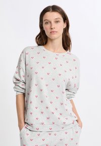 Sudadera gris con cuello redondo, que presenta un patrón repetido de pequeños corazones rosas. Tela suave y corte relajado, con puños de manga enrollados.