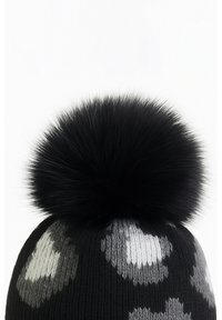 Black knit beanie featuring a textured surface with gray and white spots, topped with a large black fur pom-pom for added detail.