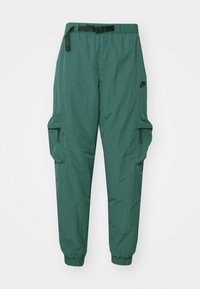 Green, lightweight cargo pants with elastic cuffs, multiple pockets, and a belt. Made from a textured, breathable material.