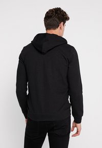 Zwarte hoodie van een katoenmix, met een trekkoordcapuchon, ribgebreide manchetten en zoom, met een zachte textuur en een aansluitend ontwerp.