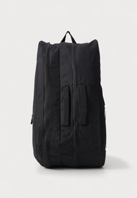 Mochila negra hecha de tejido duradero. Presenta dos asas laterales, cremalleras verticales y un acabado de textura suave. Diseño sencillo sin patrones.