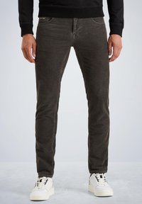 Pantaloni in velluto scosso grigio scuro con vestibilità slim, dotati di tasche frontali e cuciture a contrasto, abbinati a sneaker bianche.