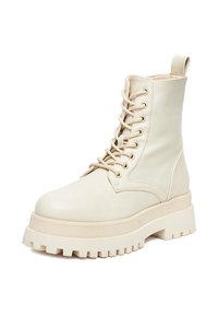 Grube, aż do połowy łydki, sznurowane botki wykonane z gładkiej, beżowej skóry z grubą, fakturowaną podeszwą platformową i pętlą z tyłu.