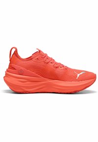 Baskets de course orange vif avec une tige texturée, des lacets et une semelle rembourrée. Présente un logo distinctif sur le côté pour le branding.