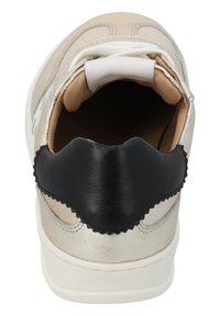 Sneaker mit einem metallic silbernen und beigen Obermaterial, schwarzem Leder-Hinterteil, weißen Schnürsenkeln und einem weichen Innenfutter.