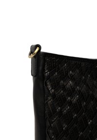 Borsa nera in pelle intrecciata con un motivo testurizzato, dotata di un dettaglio in ottone rotondo su un lato. Superficie liscia sul lato opposto.