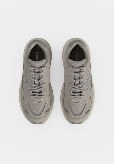 Paire de baskets de sport gris clair avec tige en mesh et synthétique, fermeture à lacets et semelle rembourrée, vues de dessus sur fond blanc.
