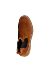 Zapato marrón de ante sin cordones con paneles laterales elásticos, suela de goma y detalles de costura alrededor de la base. Textura suave con una forma redondeada.