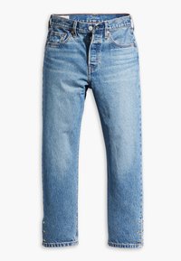 Light blue denim jeans with straight cut, five pockets, and button closure. Features contrasting stitching and decorative gold accents at hems.