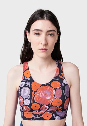 Soutien-gorge de sport fleuri en noir avec des motifs de fleurs orange vif et violet. Il a des bretelles larges et un design ajusté, fabriqué en tissu extensible.
