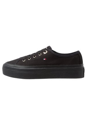 Sort lavhællet lærreds-sneakers med sort gummisål, metaløjer, sorte snørebånd og et lille rødt, hvidt og blåt logo på siden.