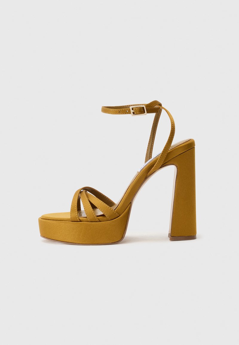 Dzelteni platforma sandales ar biezu blokveida papēdi, ar krusteniskām siksnām, potīšu siksniņu un gludu zamšādu.