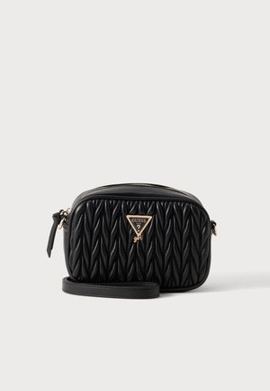 Schwarze gesteppte Umhängetasche mit goldenem Guess-Logo und verstellbarem Riemen vor weißem Hintergrund.