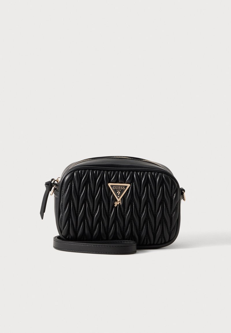 Μαύρη τσάντα crossbody με ραφές, με χρυσό λογότυπο Guess και ρυθμιζόμενο λουρί σε λευκό φόντο.