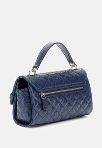 Sac à main matelassé bleu marine avec une poignée supérieure, une bandoulière détachable, et une poche zippée à l'avant. Doté de quincaillerie brillante et d'une finition texturée.