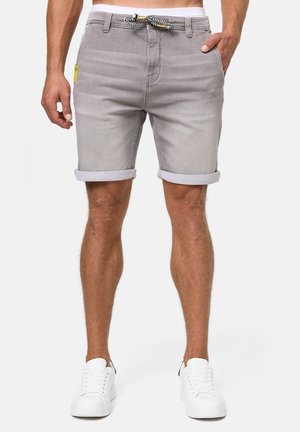 Grijze denim shorts met opgerolde randen, voorzien van een zwart-witte trekkoord, voorzakken en een klein geel label op de tailleband.