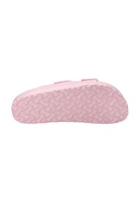 Lichtroze rubberen schoenzool met een gestructureerd grippatroon, voorzien van een breed, plat ontwerp en twee strap-sluitingen voor een veilige pasvorm.