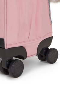 Maleta de tela rosa con una superficie texturizada, base de plástico negro y cuatro ruedas oscuras; cuenta con una cremallera en el lateral para un cierre seguro.