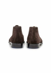 Stivaletti in suede marrone con suola in pelle liscia, caratterizzati da una punta arrotondata e cuciture minimaliste sul retro.