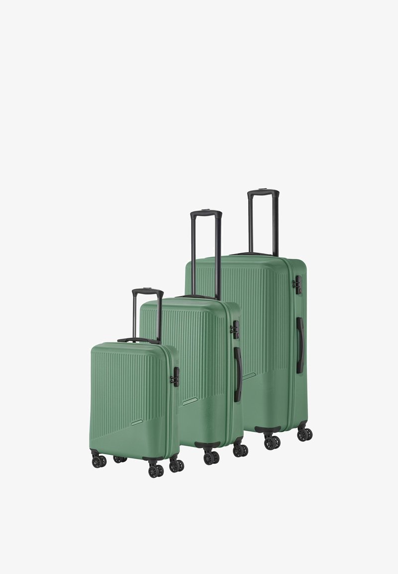 Three green hard-shell suitcases of varying sizes with ribbed texture, black handles, and four wheels each for easy mobility.