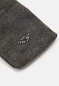 Czarna teksturowana powierzchnia z metalicznym sercem z skrzydłami. Projekt charakteryzuje się gładką, zakrzywioną krawędzią oraz subtelnymi plamkami w całej strukturze.