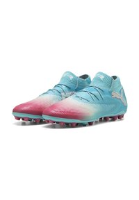 Botas de fútbol azul claro con un diseño degradado de rosa a azul, parte superior texturizada, soporte elástico para el tobillo y tacos rosas para agarre.