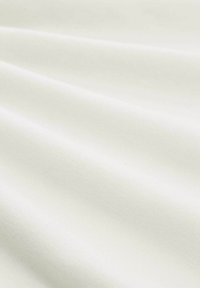 Texturiertes weißes Gewebe mit subtiler Schattierung, das weiche Falten und eine glatte Oberfläche zeigt. Das Material erscheint leicht und vielseitig einsetzbar.