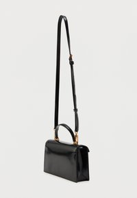 Μαύρη τσάντα από πατενταρισμένο δέρμα με δομημένο ορθογώνιο σχήμα, διαθέτοντας λαβή στο πάνω μέρος και μια μακριά ρυθμιζόμενη ταινία. Χρυσές μεταλλικές λεπτομέρειες.