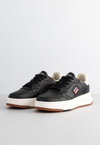 Schwarze Ledersneaker mit weißer Zwischensohle und Gummisohle. Merkmale sind der kontrastierende cremefarbene Knöchelkragen und die dekorative Seitenmarkierung.