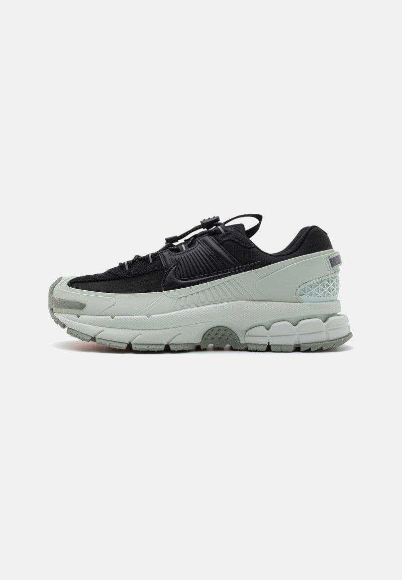 Black and light green athletic shoes featuring a textured upper, cushioned sole, and streamlined design with a secure lacing system.