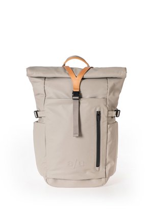 Beiger Rolltop-Rucksack mit vertikalem Reißverschlussfach vorne, verstellbaren Seitengurten sowie Griff und Schnallengurt aus braunem Leder.