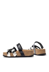 Black and white patterned sandals with cork wedge sole, featuring two wide straps and a back strap for support. Smooth leather accents.