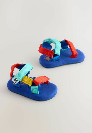 Blå sandaler med blødt materiale, udstyret med justerbare røde, gule og turkise stropper, samt en tekstureret sål for godt greb.