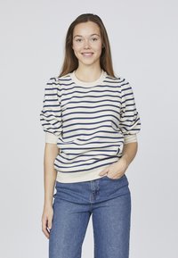 Stribet cremet og marineblåt pullover med puffede ærmer og ribbet halsudskæring, parret med blå jeans. Blød stofstruktur og afslappet pasform.