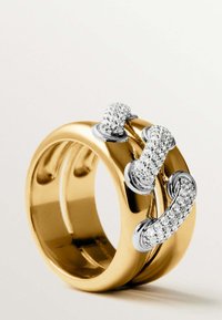 Anillo de banda de oro con acentos plateados entrelazados, incrustado con pequeños diamantes, que presenta superficies lisas y pulidas.