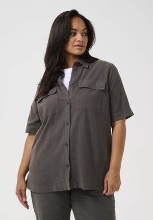 Camisa de manga corta, con botones, en tela gris oscura con un acabado texturizado; cuenta con dos bolsillos en el pecho y un corte relajado.