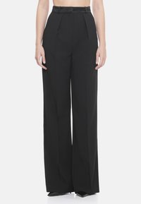 Pantalones de pierna ancha negros con una cintura alta, frente plisado y tejido suave. El diseño incluye pasadores para cinturón y un ajuste entallado.