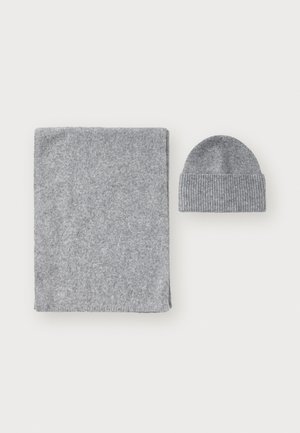 Grå strikket hatt og matchende rektangulær skjerf. Begge har en myk tekstur og en ensfarget design, med hatten som har et ribbet mønster.