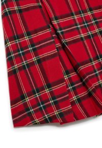 Tissu à carreaux rouges avec un motif de lignes noires, jaunes et blanches. Le matériau semble doux avec une texture lisse et des bords repliés.