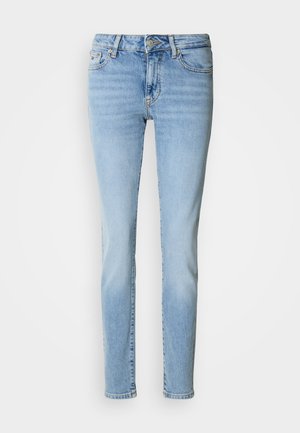 Svetlomodré denimové rifle s úzkym strihom, stredne vysoko posadeným pásom, štýlom s piatimi vreckami a jemným vyblednutím na stehnách. Klasické šitie.