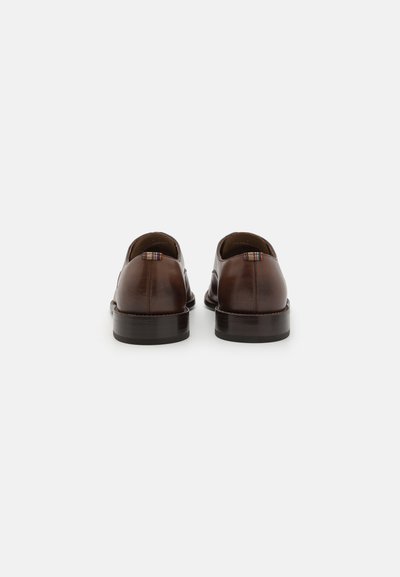 Chaussures en cuir marron à la finition lisse, dos arrondi, talon bas et détail de languette coloré à l'arrière.