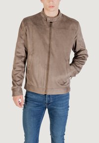 Giubbotto di pelle marrone con colletto alto, cerniera frontale, tasche laterali e polsini a costine. Texture liscia con dettagli di cucitura minimi.