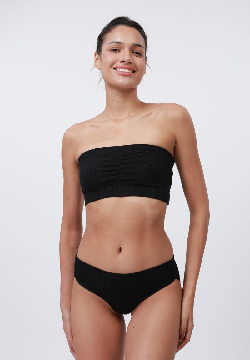 Svart ribbet bandeau topp med samlet senterdetalj, sammen med matchende lavtsittende bikinibunn, begge med en glatt tekstur.